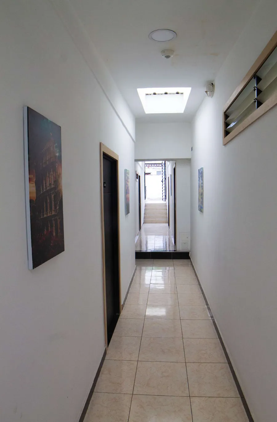Pasillo con claraboya y piso de porcelanato